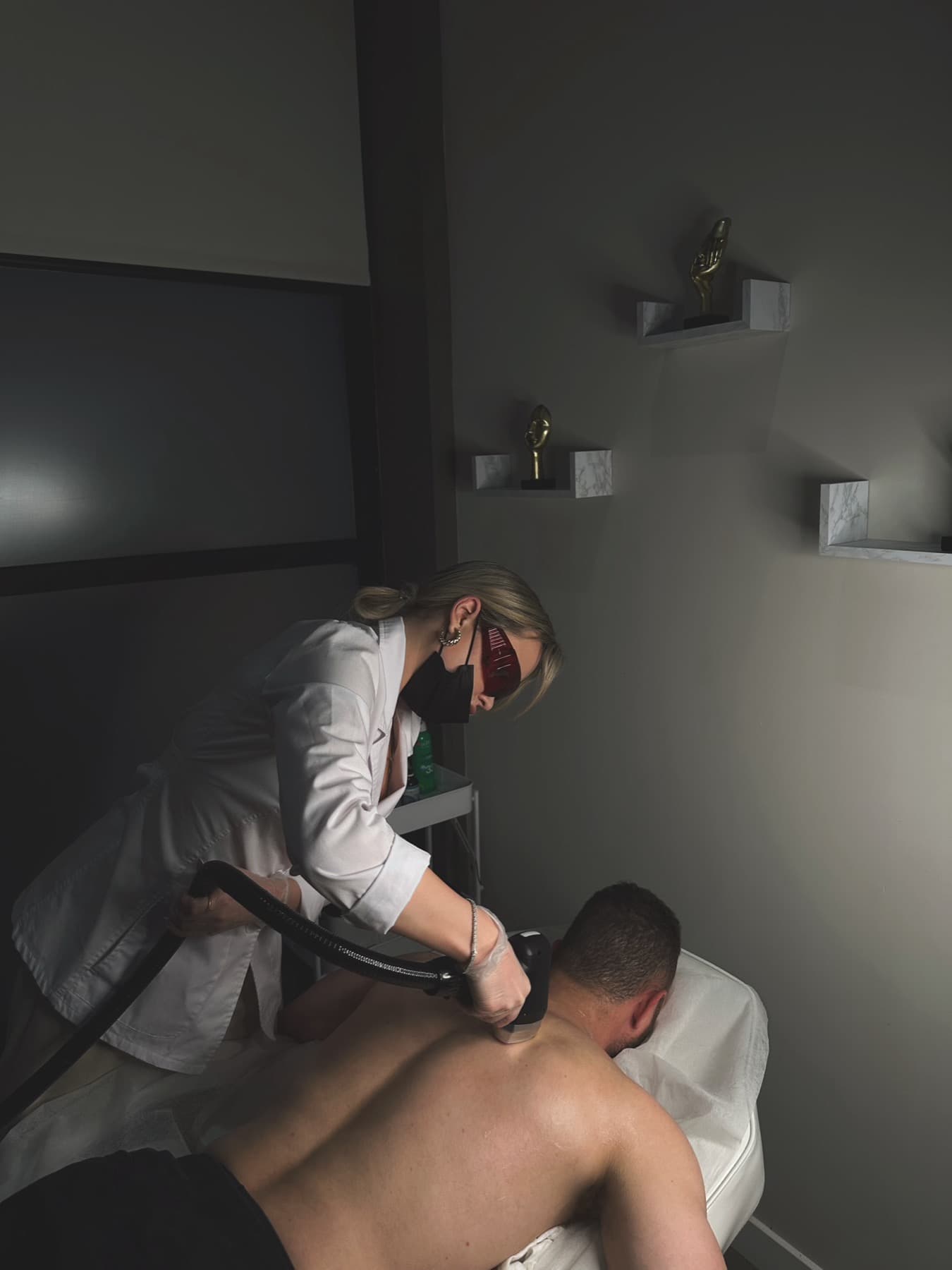 Laser hair removal treatment in progress on a client's back
